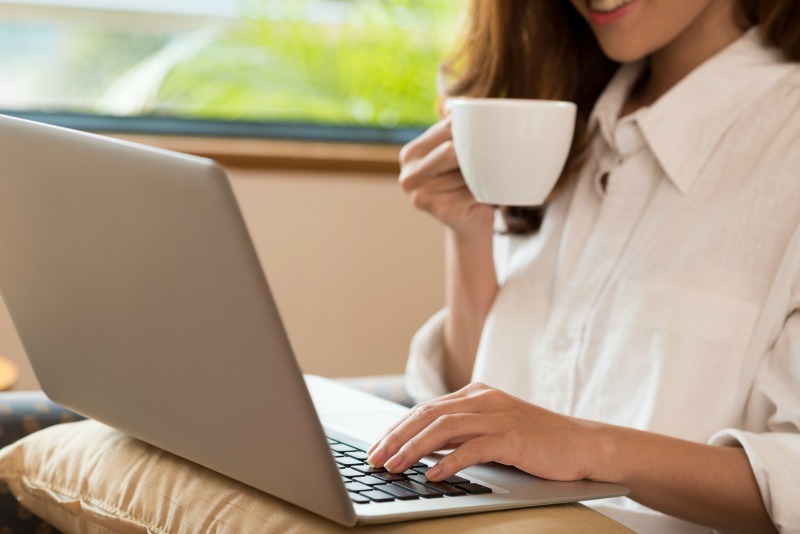 woman working on laptop and drinking coffee